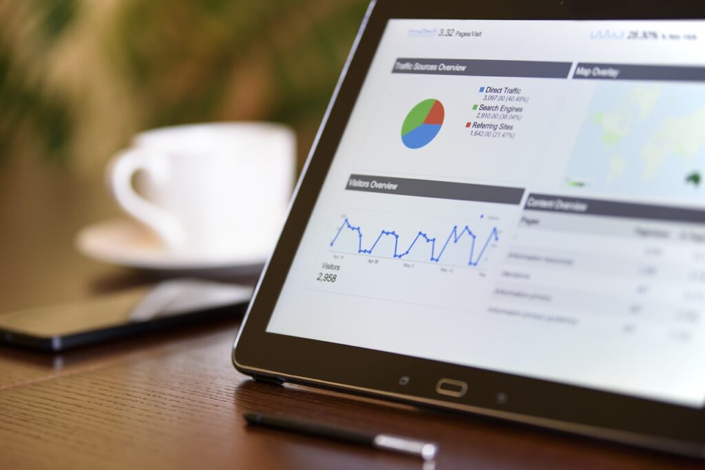 A tablet with marketing analytics data featured, and a cup of coffee in the background.